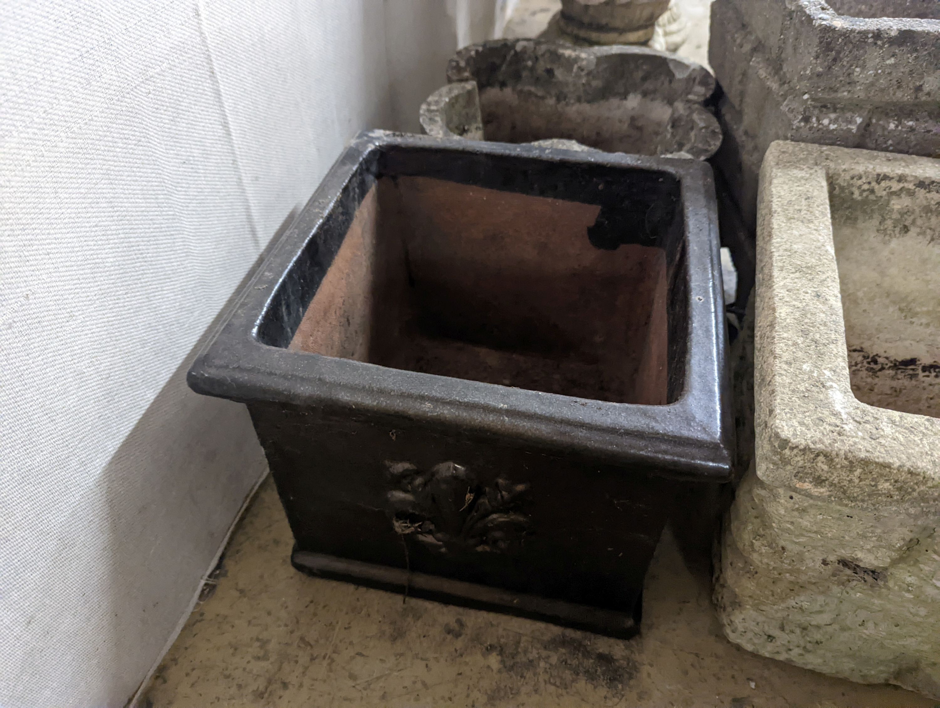 Three reconstituted stone garden planters and a terracotta planter, largest width 36cm, height 35cm